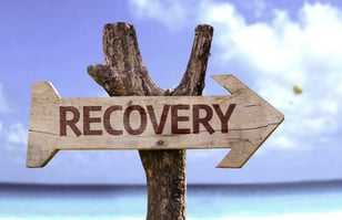 Recovery wooden sign with a beach on background